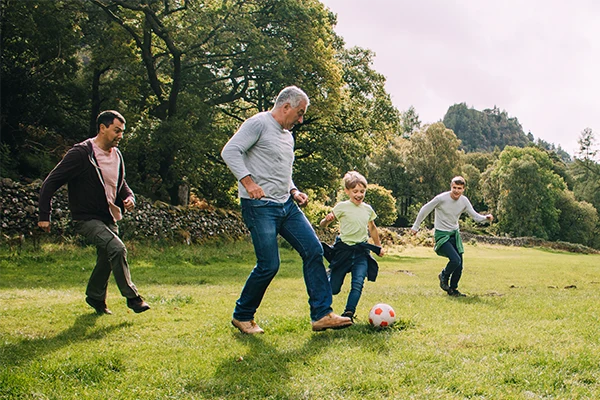 Family In The Grass Playing Soccer