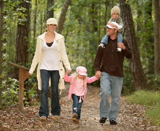 Four people walking along a wooded path